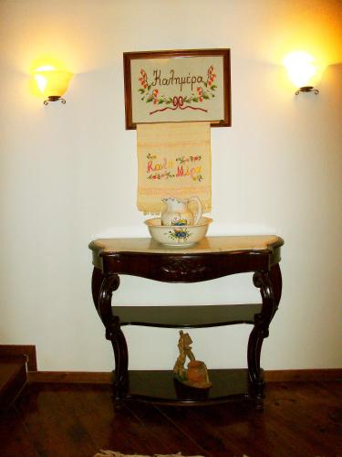 a table with a vase and a picture on the wall at Hotel Ligeri in Elati Trikalon