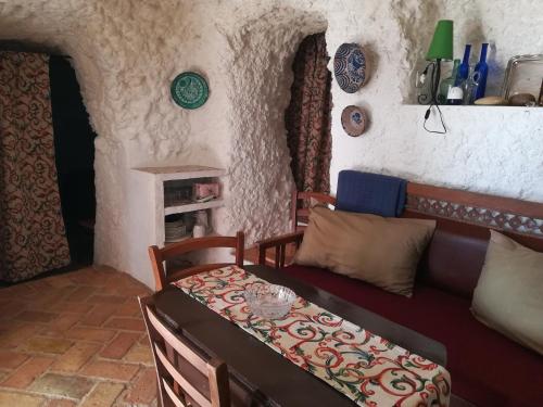 a living room with a couch and a bed at Cueva El Madrono in Pegalajar