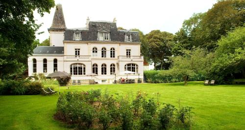 een groot wit huis met een groot grasveld bij Château de la Marine in Wimille