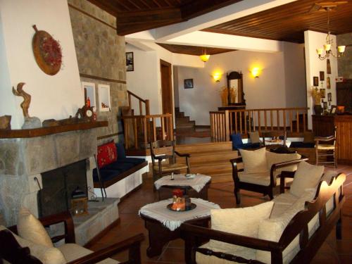 a living room with a fireplace and tables and chairs at Hotel Ligeri in Elati Trikalon