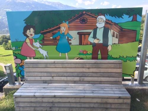a mural of a family in front of a house at Hotel Restaurant Heidihof in Maienfeld