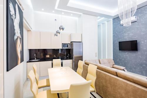 un soggiorno con divano, tavolo e sedie di LEOGRAND DELUXE Apartments on Doroshenka 17 a Lviv