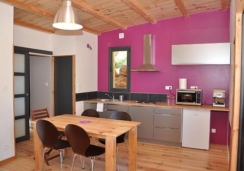 ジニャックにあるEco-gîte de Tit'âneの紫の壁のキッチン(木製テーブル付)
