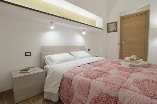 - une chambre avec un lit doté d'une couette rouge et blanche dans l'établissement Le Maioliche Junior Suite, à Agrigente