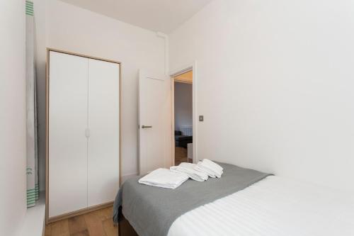 a white bedroom with a bed with a mirror at Gorgeous 2 bed flat near Central London for 6 in London
