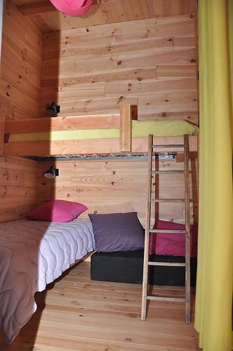 une chambre avec deux lits superposés et une échelle dans l'établissement Eco-gîte de Tit'âne, à Gignac