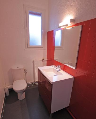 a bathroom with a toilet and a sink and a mirror at Hotel Italia in Tours