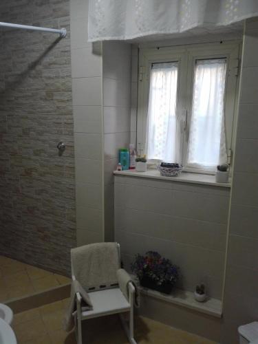 a bathroom with a chair and a window and a shower at b&b ERCOLANO Scavi in Ercolano