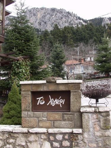 a sign on a stone wall with a mountain in the background at Hotel Ligeri in Elati Trikalon