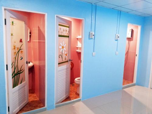 巴東海灘的住宿－芭東旺旺旅舍，浴室拥有蓝色和粉红色的墙壁,设有卫生间