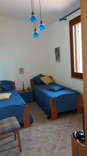1 Schlafzimmer mit 2 Betten und blauer Bettwäsche in der Unterkunft Villa Marino in Mazara del Vallo