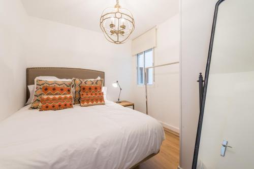 マドリードにあるFor You Rentals Madrid Rio apartment MAZ10のベッドルーム(白いベッド1台、シャンデリア付)