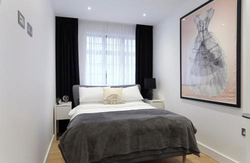 a bedroom with a bed and a large window at Veeve - Marylebone Mews in London