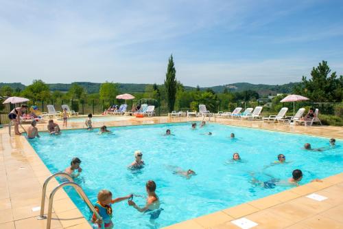 un groupe de personnes dans une piscine dans l'établissement Résidence Goélia Le Hameau de la Vézère, au Bugue