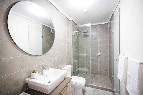 a bathroom with a sink toilet and a mirror at Waters Edge Self-Catering Apartment in Cape Town