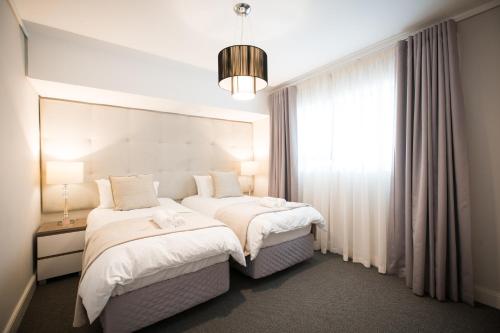 a hotel room with two beds and a window at Waters Edge Self-Catering Apartment in Cape Town