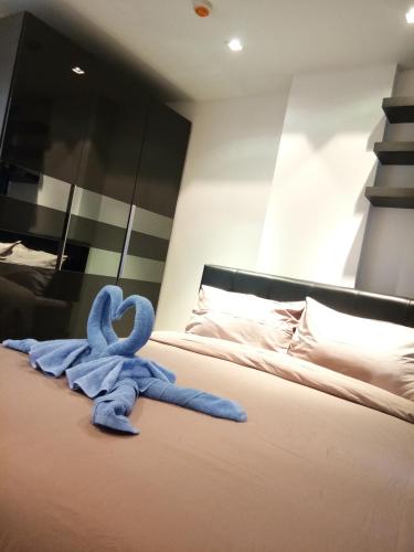 a blue stuffed animal sitting on top of a bed at Mosaic Condminum A24m by malai in Mae Pim