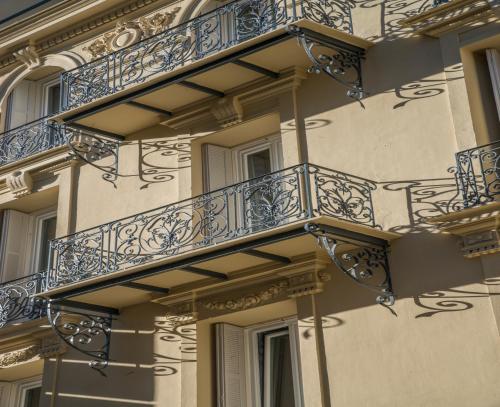 a building with blue balconies on the side of it at Hotel Paganini in Nice