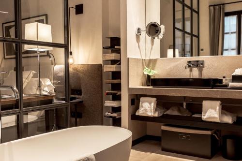 a bathroom with a tub and a large mirror at Sant Francesc Hotel Singular in Palma de Mallorca