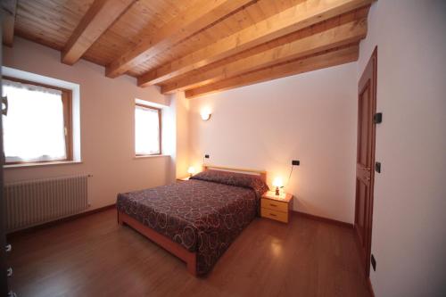 een slaapkamer met een bed en twee lampen op een tafel bij Albergo diffuso Valcellina e Val Vajont in Cimolais in Basoia