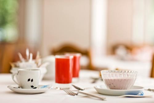 a table with two cups and forks and spoons at Hotel Apollo in Cesenatico