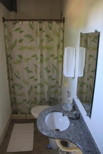 a bathroom with a sink and a shower curtain at Pousada Vista Bela in Guarapari