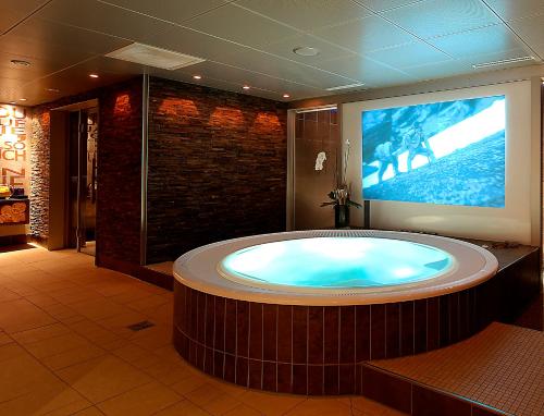 una grande vasca idromassaggio in una camera con TV di Hotel Spinne Grindelwald a Grindelwald