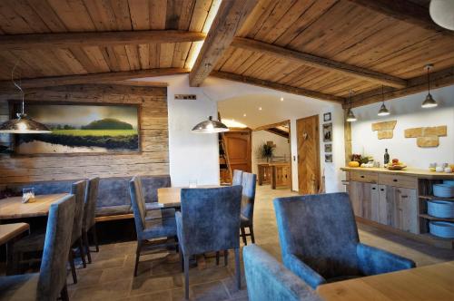 a dining room with wooden ceilings and blue chairs at Chalets Petry Spa & Relax in Bettel