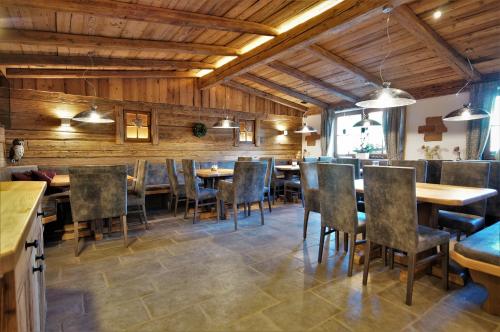 a restaurant with wooden walls and tables and chairs at Chalets Petry Spa & Relax in Bettel