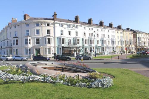 a large white building with a fountain in front of it at Beachside Guest House in Llandudno