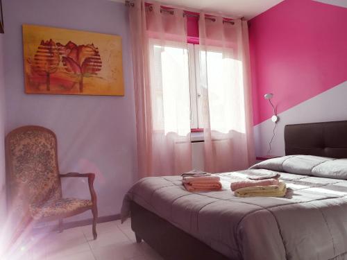 - une chambre aux murs roses avec un lit et une chaise dans l'établissement Appart' Charmant Piccola Venezia, à Colmar