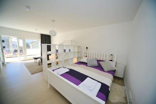 a bedroom with a large bed with purple and white sheets at Rubeši in Kastav