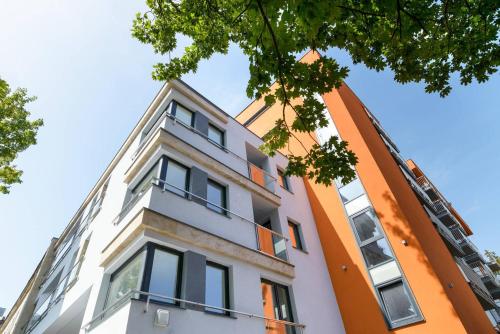 un bâtiment orange et blanc avec fenêtres dans l'établissement Good Time Apartments Strzelecka B, à Poznań