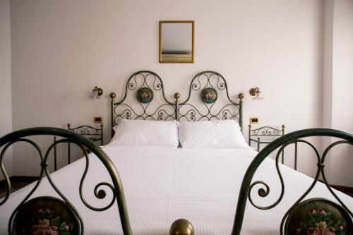 ein Schlafzimmer mit einem weißen Bett mit Metallrahmen in der Unterkunft Hotel e Locanda La Bastia in Valeggio sul Mincio