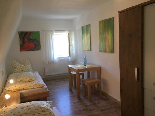 Kleines Zimmer mit einem Bett und einem Tisch in der Unterkunft Ferienwohnung Richtermühle in Saupsdorf