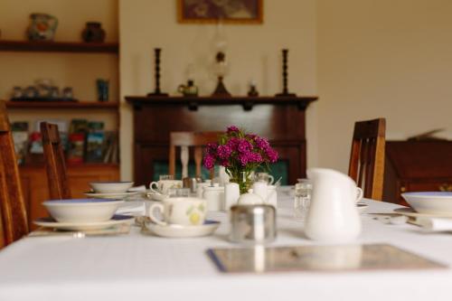 a table with white dishes and a vase of flowers at Hordley Hall in Ellesmere