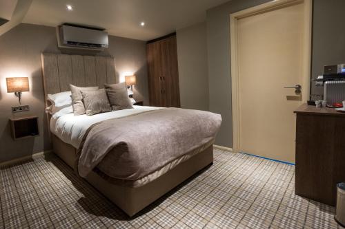a bedroom with a bed and a tv on the wall at The Grand at Grasmere in Grasmere