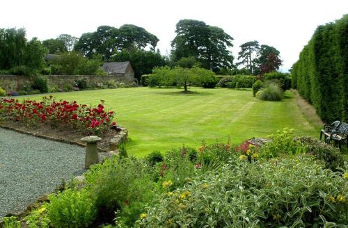 a garden with a green lawn and flowers at Hordley Hall in Ellesmere