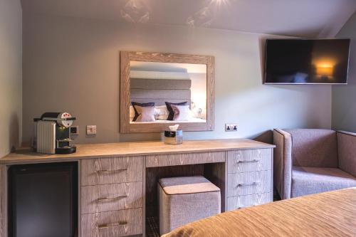 a room with a vanity with a mirror and a chair at The Grand at Grasmere in Grasmere