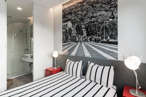 a bedroom with a black and white photo on the wall at FAA Rentals 31 de Janeiro by An Island Apart in Funchal