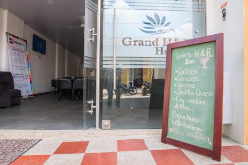 a sign in front of a glass door of a store at Hotel Grand H&R in Villeta