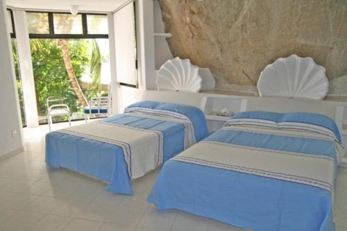 three beds in a room with blue and white at Acapulco Villa Brisas 26 in Acapulco