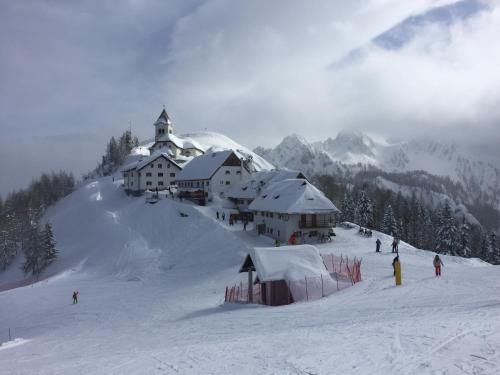 a church on top of a snow covered mountain at Berghaus Christel, bergbeek in grote tuin in Arnoldstein