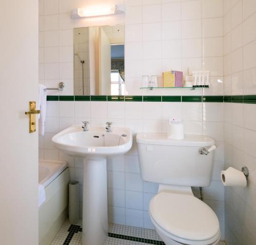 a white bathroom with a toilet and a sink at Roseleigh House in Belfast