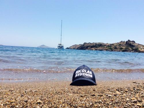 un sombrero sentado en una playa con el océano en Nicolas Studios, en Skala