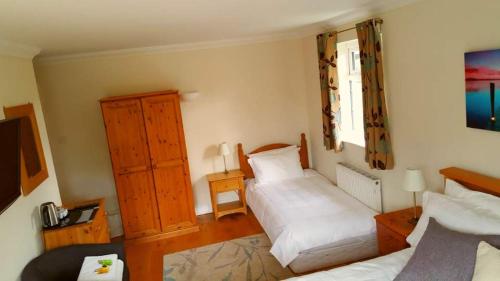 a bedroom with two beds and a dresser at The Oak at Dewlish in Dorchester