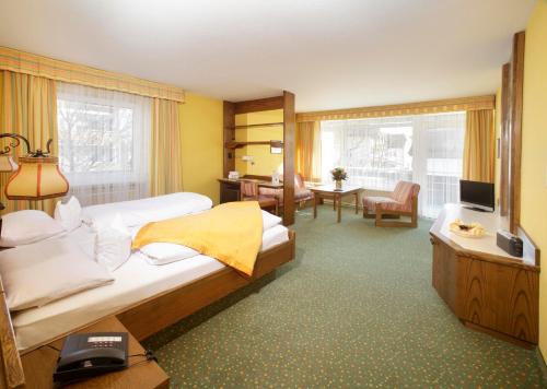 a hotel room with two beds and a television at Kneipp-Kurhotel Steinle in Bad Wörishofen