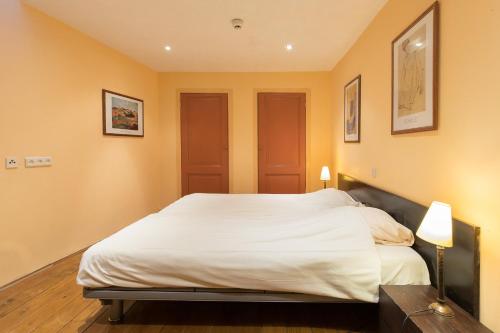 a bedroom with a large bed with white sheets at Hotel de Vischpoorte, centrum Deventer en aan de IJssel in Deventer