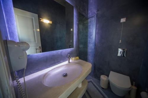 a bathroom with a sink and a toilet at Ianthe Apartments & Villa in Oia