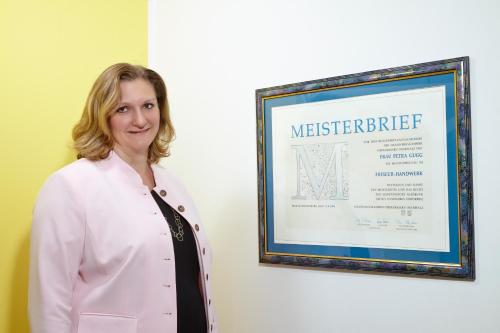a woman in a white lab coat standing in front of a sign at Kneipp-Kurhotel Steinle in Bad Wörishofen